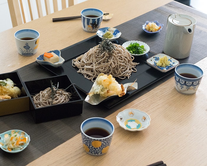 食卓に蕎麦や天ぷらが並んでいてamabroの豆皿やそば猪口が使われている