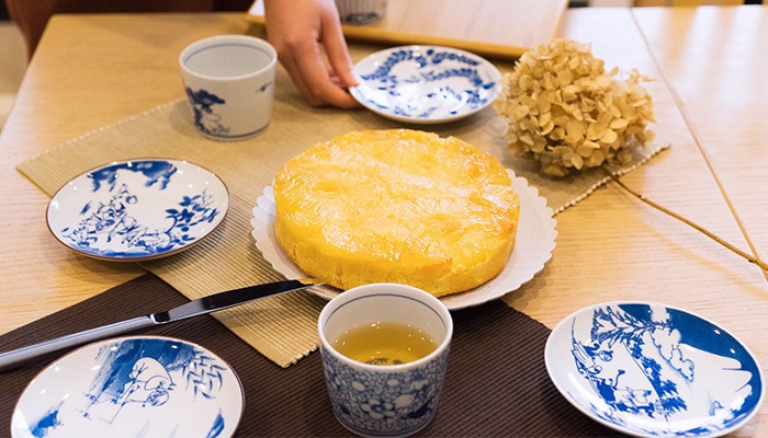 Cake at the center of the table and blue and white Moomin plates surround the cake