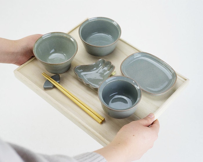 A woman serves a tableware set of OKUIZOME