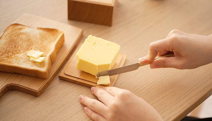 バターケースの底板に乗ったバターを切っている様子
