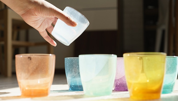 Colored glassware solito. A woman has white glass