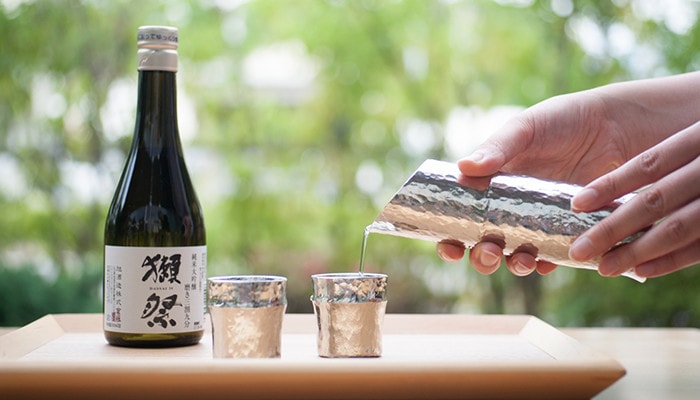 Pouring Japanese sake with bamboo katakuchi