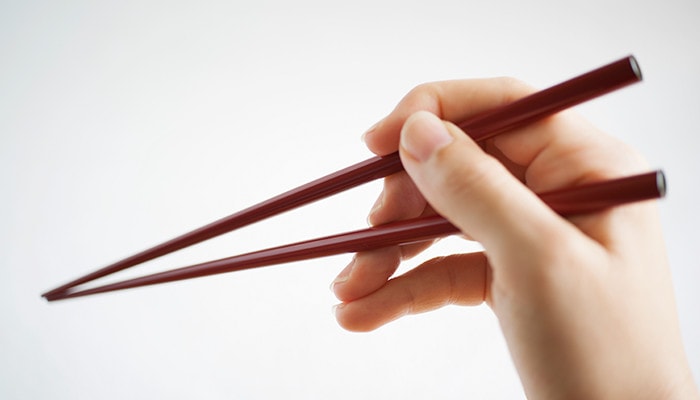 A woman is using oval lacquered chopsticks of Wajima Kirimoto