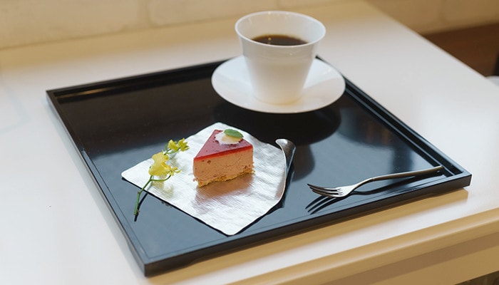 お盆の上にケーキの乗ったすずがみとコーヒーの入ったカップが乗っている