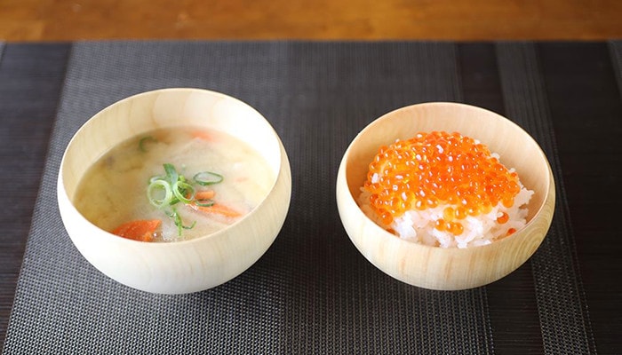 Miso soup and rice with salmon in wooden bowl