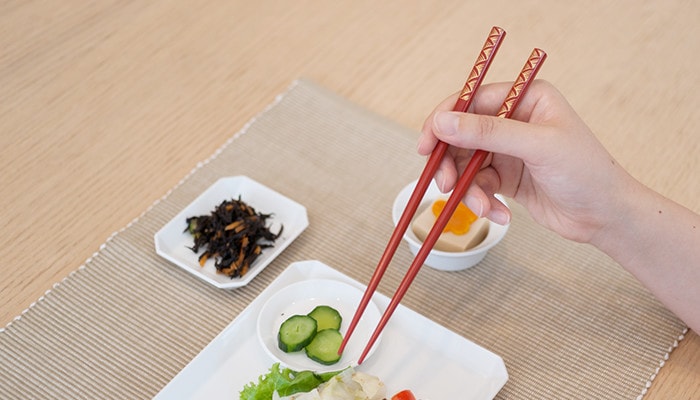 A woman has Wajima lacquer chopsticks from Hashimoto Kousaku Shikkiten